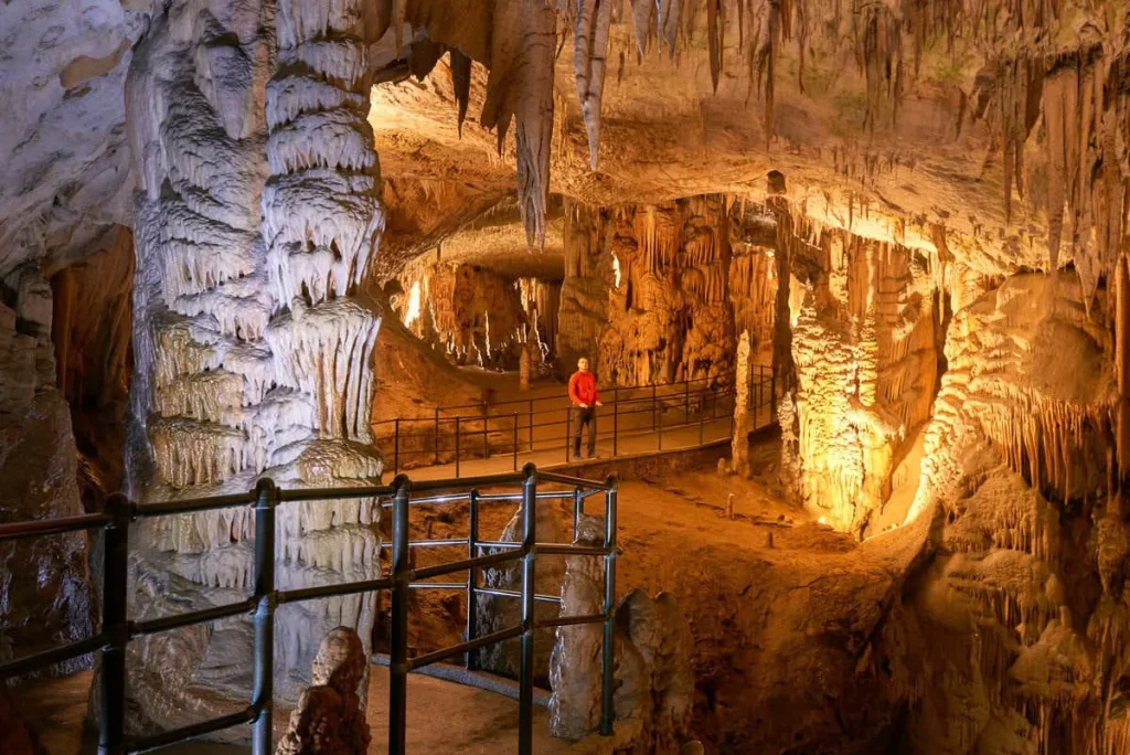 Un visiteur dans la grotte de Postojna