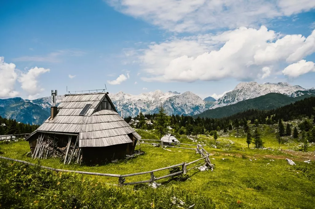 Mountain cottage hut or house on hill Velika Planina alpine meadow landscape. Eco farming. Travel destination for family hiking. Kamnik Alps, Slovenia. Big Plateau.
